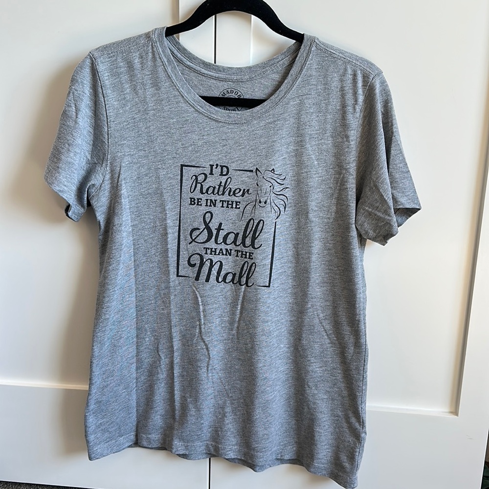 Grey tee shirt with text: “I’d rather be at the stall than the mall”